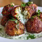 Vibrant green tahini drizzled over crispy falafel balls, a flavorful vegan appetizer or main dish.  