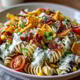 Vibrant Taco Pasta Salad with Doritos and Avocado Ranch, featuring crunchy chips and fresh vegetables in a creamy dressing.  