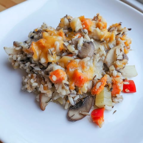 A close-up of a bubbling wild rice casserole, fragrant with herbs and savory broth.