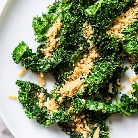 Garlic Parmesan Kale Salad with massaged greens, creamy dressing, and crispy panko topping, served in a rustic white bowl.