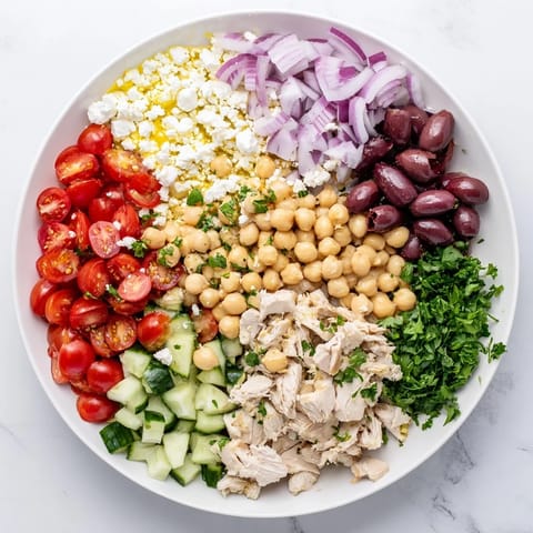 Close-up of a hearty Mediterranean Chickpea Chicken Salad, featuring plump chickpeas, briny Kalamata olives, and fresh parsley on a rustic plate.