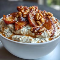 Creamy overnight oats topped with tender cinnamon-spiced apples and crunchy toasted walnuts, a wholesome and satisfying breakfast.